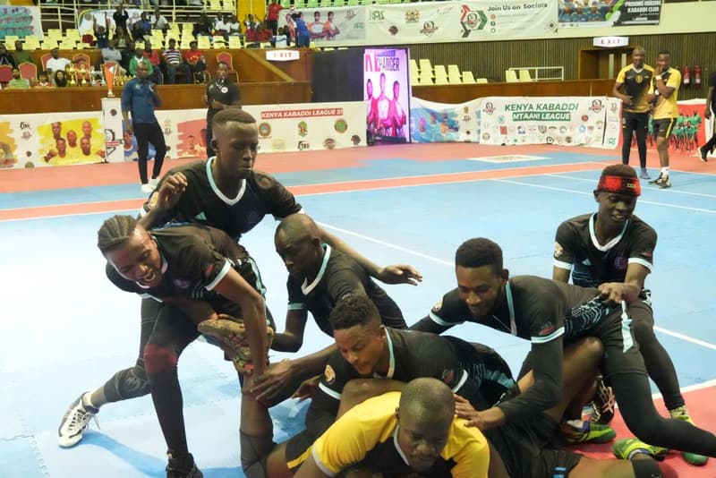 Defenders hold a raider on the mat during a Kenyan league kabaddi match.